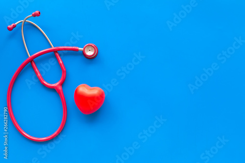 Stethoscope and heart for family doctor set to cure of cardiac disease on blue background top view space for text