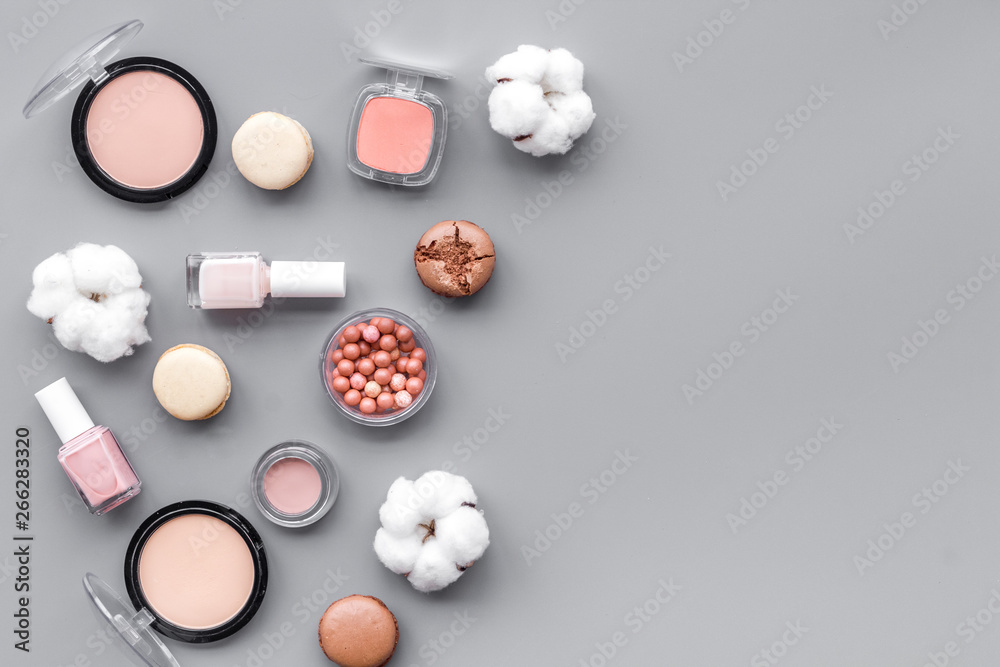decorative cosmetics for make-up with macaroon cookies on gray tabletop background space for text decorative cosmetics for make-up with macaroon cookies on gray tabletop background space for text
