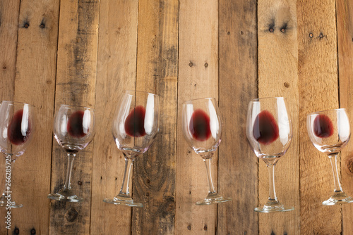 Red wine in transparent wine glasses on a wooden background. Bojole nouveau, wine bar, winery, winemaking, wine tasting concept, Flat lay photo