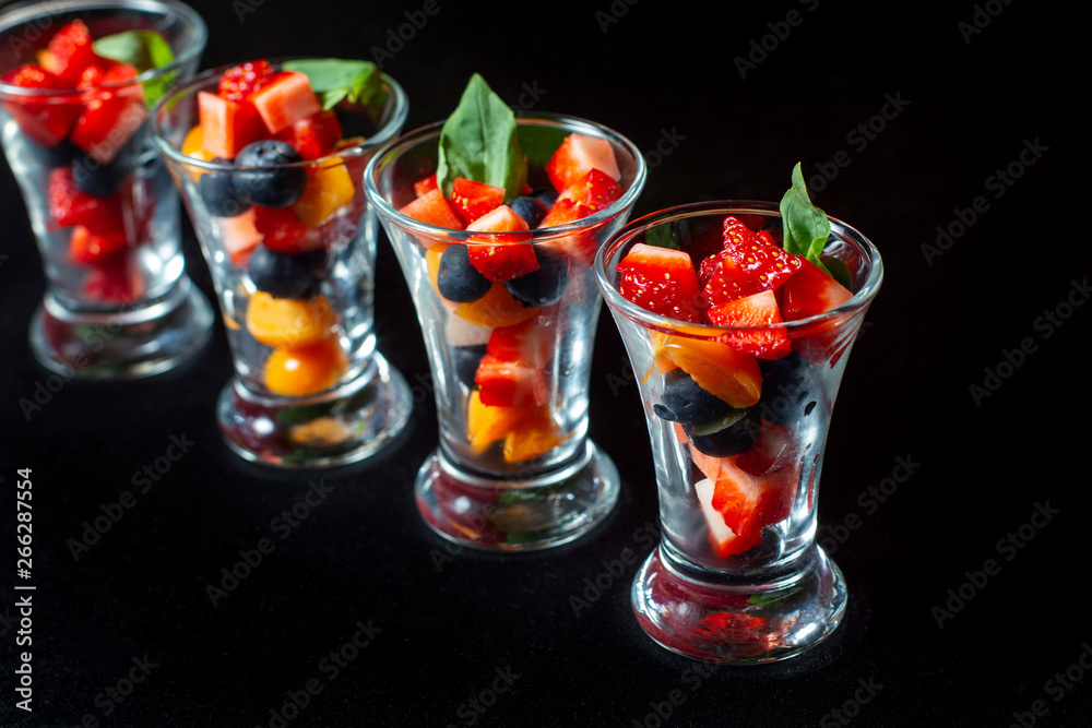 Four cups with sliced strawberries and blueberries. Four cups with sliced strawberries and blueberries.