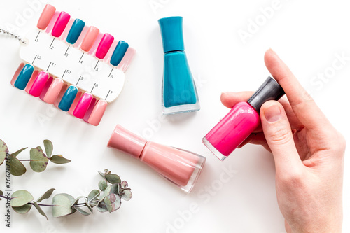 cosmetics for manicure with nail polish and palette for spring nail design in nail bar on white background top view