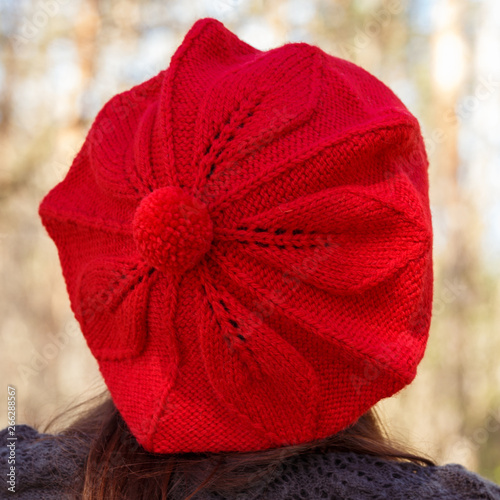 Outdoor close up portrait of young beautiful happy smiling girl wearing french style red knitted beret