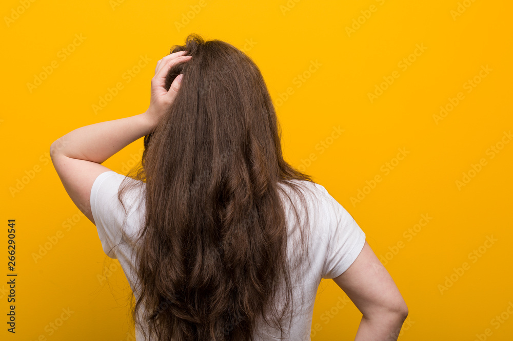Obraz premium Young curvy plus size woman from behind thinking about something.