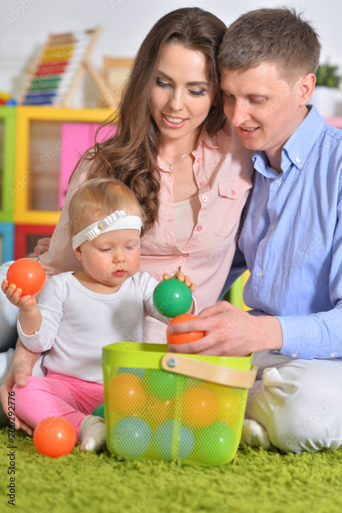 Fototapeta premium Portrait of happy parents playing with daughter
