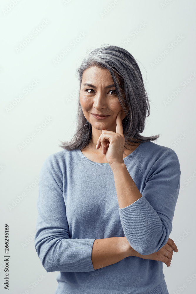 Asian woman smiling and pointing her finger to her cheek Asian woman smiling and pointing her finger to her cheek