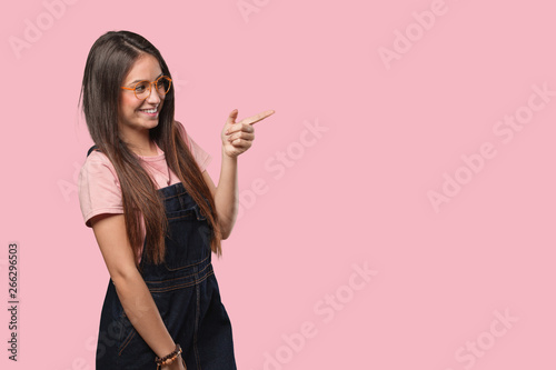 Young cool woman pointing to the side with finger