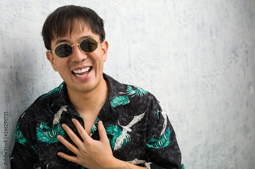 Принти на полотні Young chinese man wearing summer outfit laughing and having fun