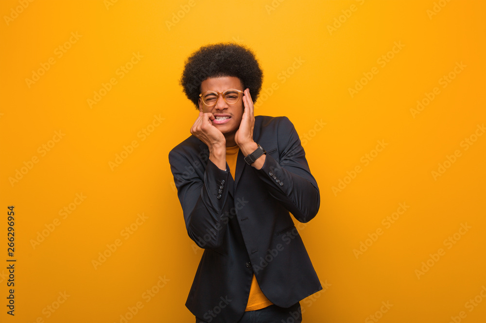 Young business african american man over an orange wall desperate and sad Young business african american man over an orange wall desperate and sad