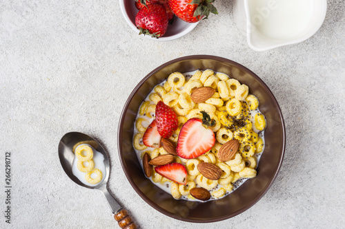 Bowl with cereal rings cheerios, strawberries and milk. Traditional breakfast concept photo