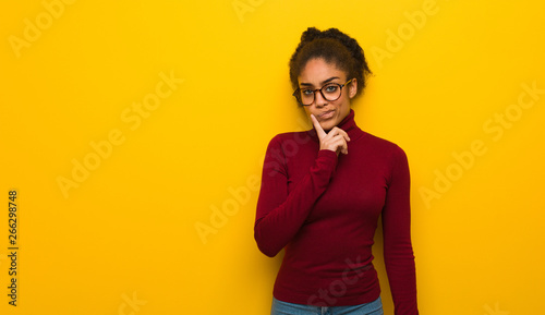 Young black african american girl with blue eyes doubting and confused photo