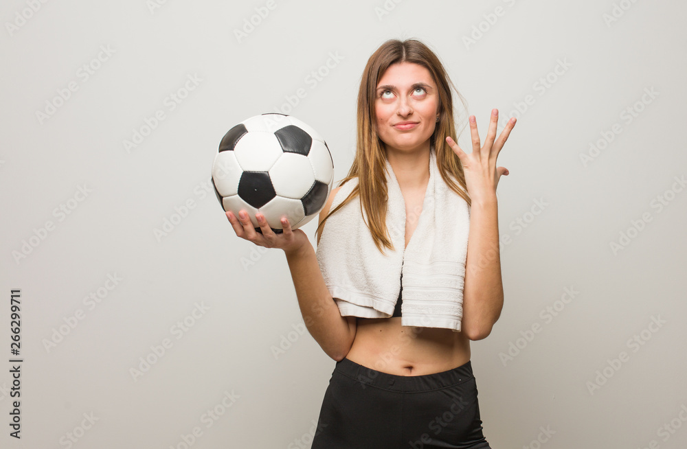 Young fitness russian woman very scared and afraid. Holding a soccer ball. Young fitness russian woman very scared and afraid. Holding a soccer ball.