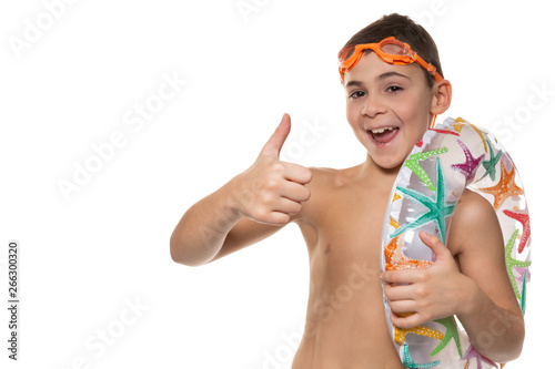 happy boy with orange swimming goggles and an inflatable circle on his shoulder, laughs and shows gestures, concept, on a white background, isolate