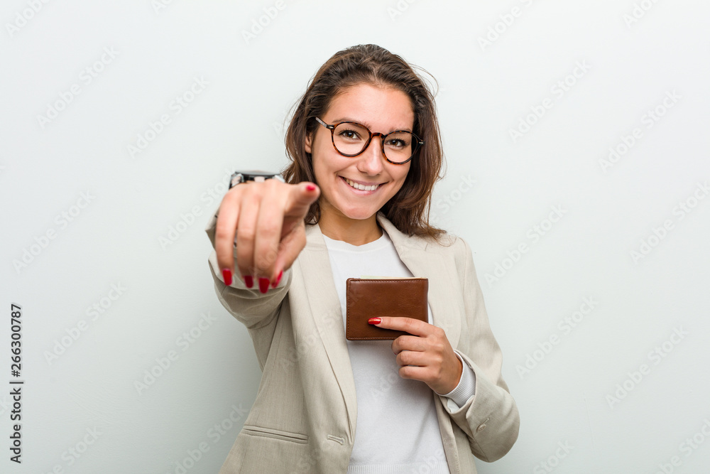 Young european business woman holding a wallet cheerful smiles pointing to front. Young european business woman holding a wallet cheerful smiles pointing to front.