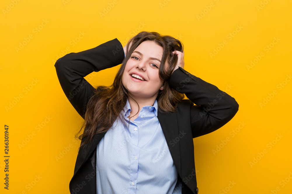 Young plus size caucasian business woman laughs joyfully keeping hands on head. Happiness concept. Young plus size caucasian business woman laughs joyfully keeping hands on head. Happiness concept.