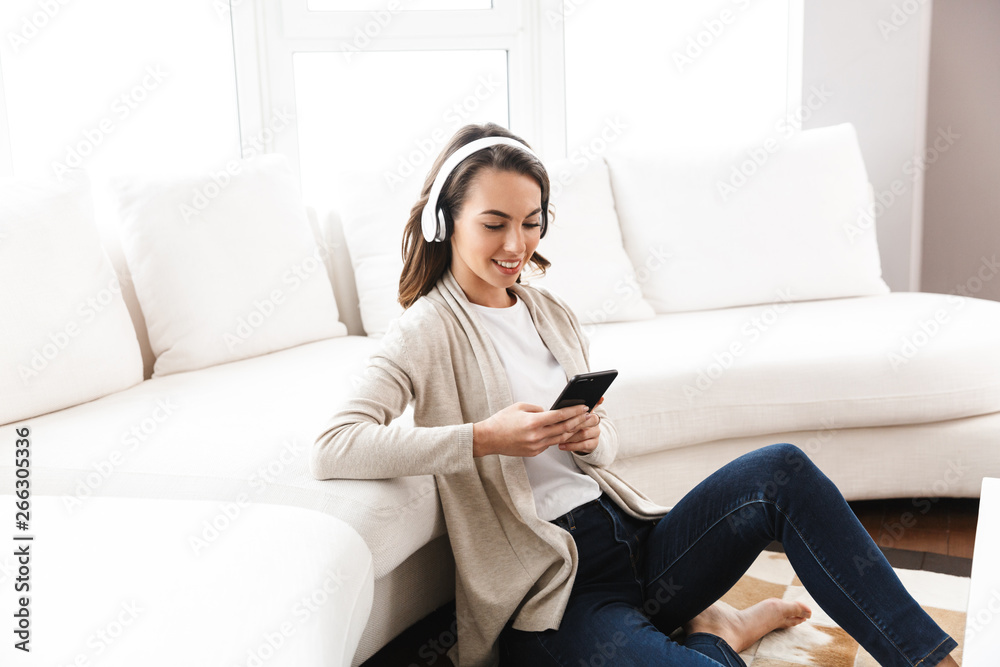 Smiling beautiful girl relaxing at a couch at home Smiling beautiful girl relaxing at a couch at home