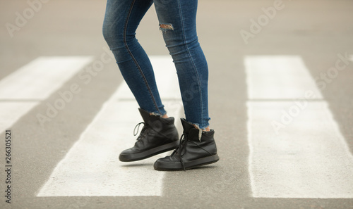 close up of woman legs walking on crosswalk. 