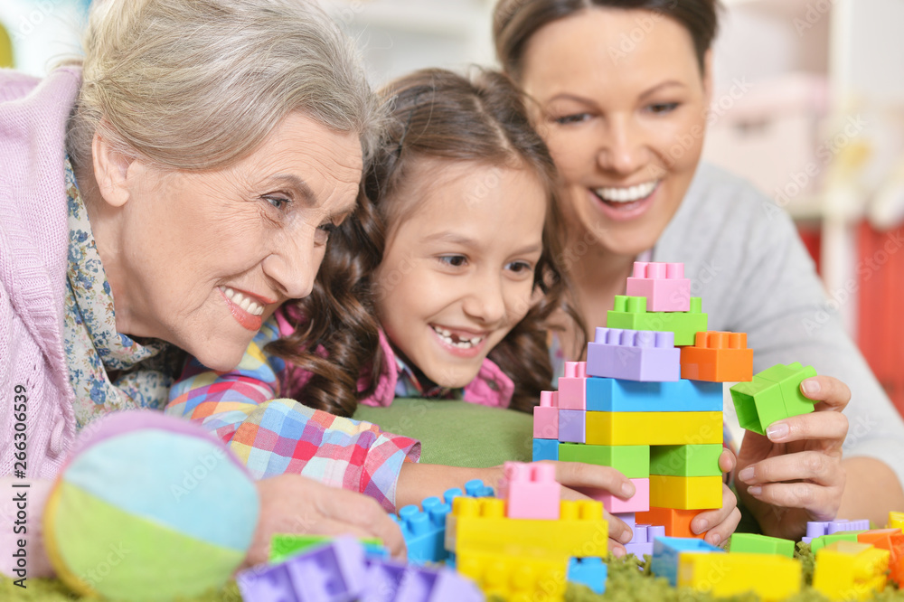 Happy smiling family playing with colorful plastic blocks Happy smiling family playing with colorful plastic blocks