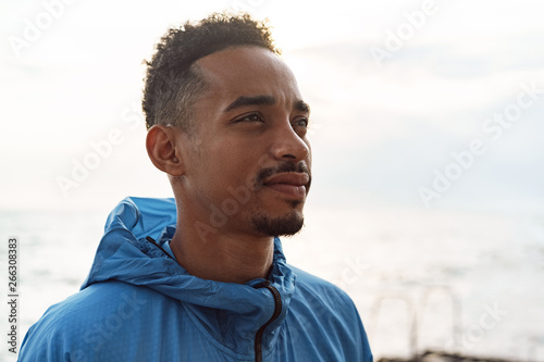 Strong handsome young african sports man outdoors at the beach sea. © Drobot Dean