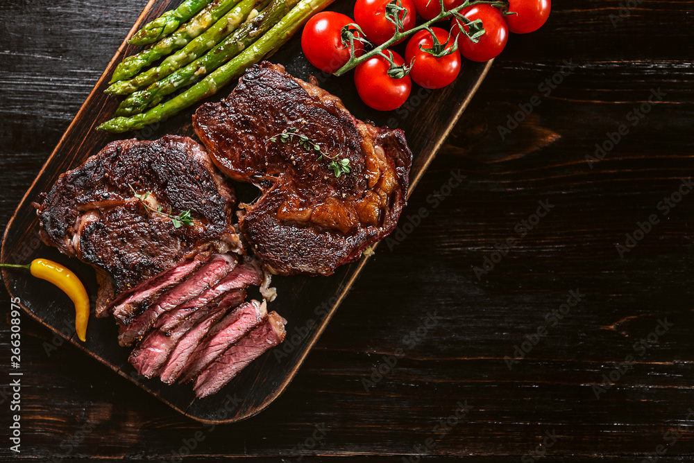Dinner for two juicy delicious steaks, asparagus with parmesan and vegetables.