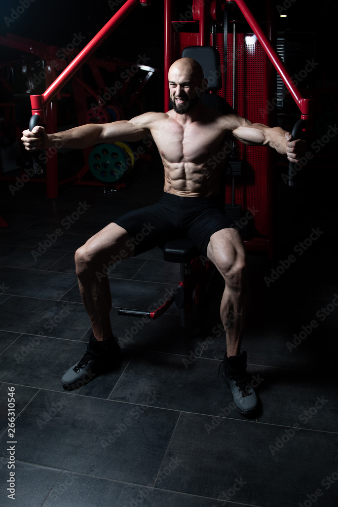 Bodybuilder Exercising Chest On Machine Bodybuilder Exercising Chest On Machine