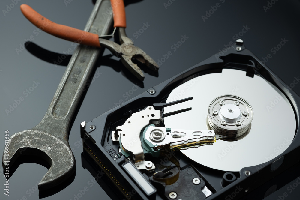 Hard drive from the computer hdd with mirror effect. Close-up, macro, on a black background. And repair tools. Hard drive from the computer hdd with mirror effect. Close-up, macro, on a black background. And repair tools.