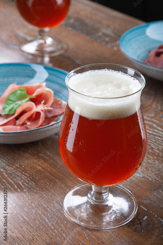 Close up view on cold amber beer in a glass with snack at bar on table. Bar image cocnept with copy space for logo or brand. Refreshing alcoholic drinks. Tasty restaurant snacks Close up view on cold amber beer in a glass with snack at bar on table. Bar image cocnept with copy space for logo or brand. Refreshing alcoholic drinks. Tasty restaurant snacks