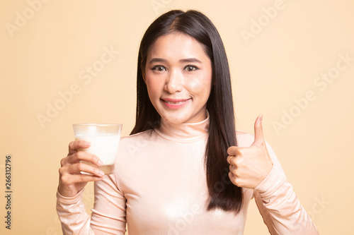 Healthy Asian woman drinking a glass of milk thumbs up.
