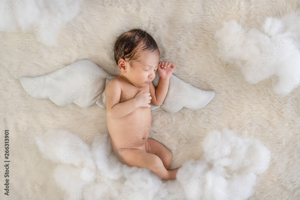 cute Asian inflant baby with tiny wings sleeping on carpet with white  clound in concept of angle in sky Stock Photo | Adobe Stock