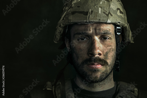 No feels and emotions. Close up portrait of young male soldier. Man in military uniform on the war. Depressed and having problems with mental health and emotions, PTSD, rehabilitation.