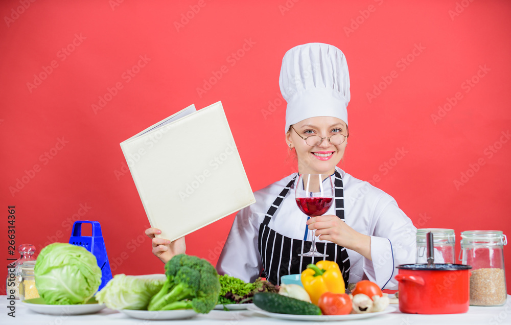 Traditional cuisine. Culinary school concept. Female in hat and apron knows everything about culinary arts. Culinary expert. Woman chef cooking healthy food. Girl read book top best culinary recipes Traditional cuisine. Culinary school concept. Female in hat and apron knows everything about culinary arts. Culinary expert. Woman chef cooking healthy food. Girl read book top best culinary recipes