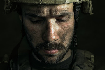 How much is my life. Close up portrait of young male soldier. Man in military uniform on the war. Depressed and having problems with mental health and emotions, PTSD, rehabilitation.