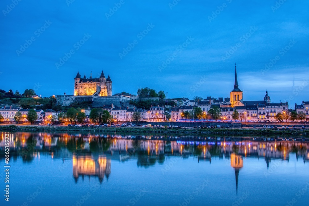Panorama of Saumur at night with the medieval castle and the Saint-Pierre church, France.