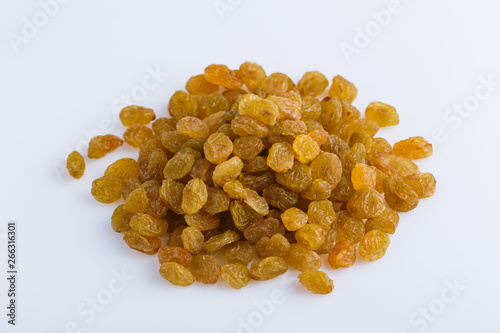 golden raisins on a white acrylic background