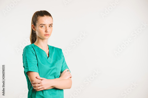 Cheerful female doctor in green uniform.