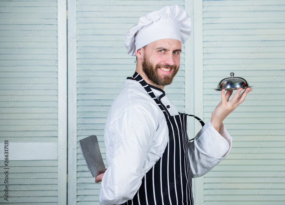 cook in restaurant, uniform. Professional in kitchen. culinary cuisine. confident man in apron and hat hold tray. chef ready for cooking. bearded man loves eating food. compliment from chef