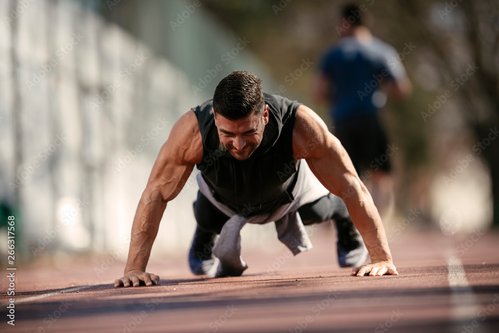 Fitness man doing push ups outdoor. Athlete training. Fitness man doing push ups outdoor. Athlete training.