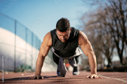Fitness man doing push ups outdoor. Athlete training.