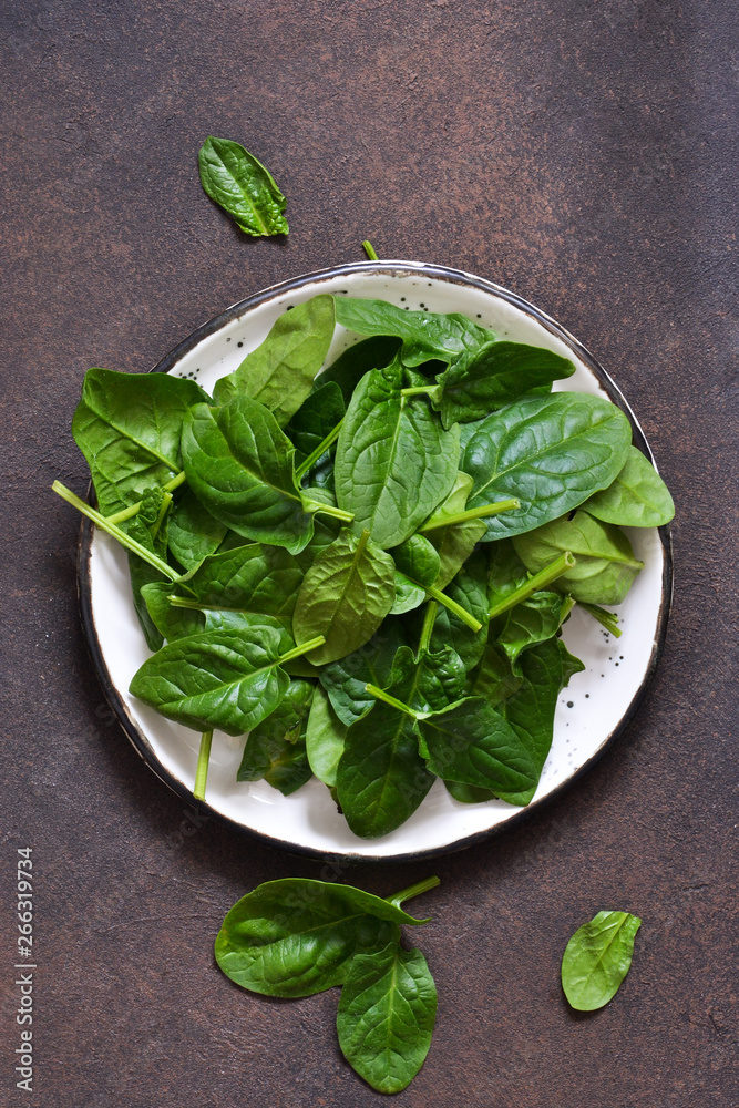 Fresh, young green spinach on a concrete background. View from above. Fresh, young green spinach on a concrete background. View from above.