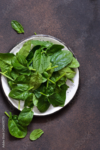 Fresh, young green spinach on a concrete background. View from above.