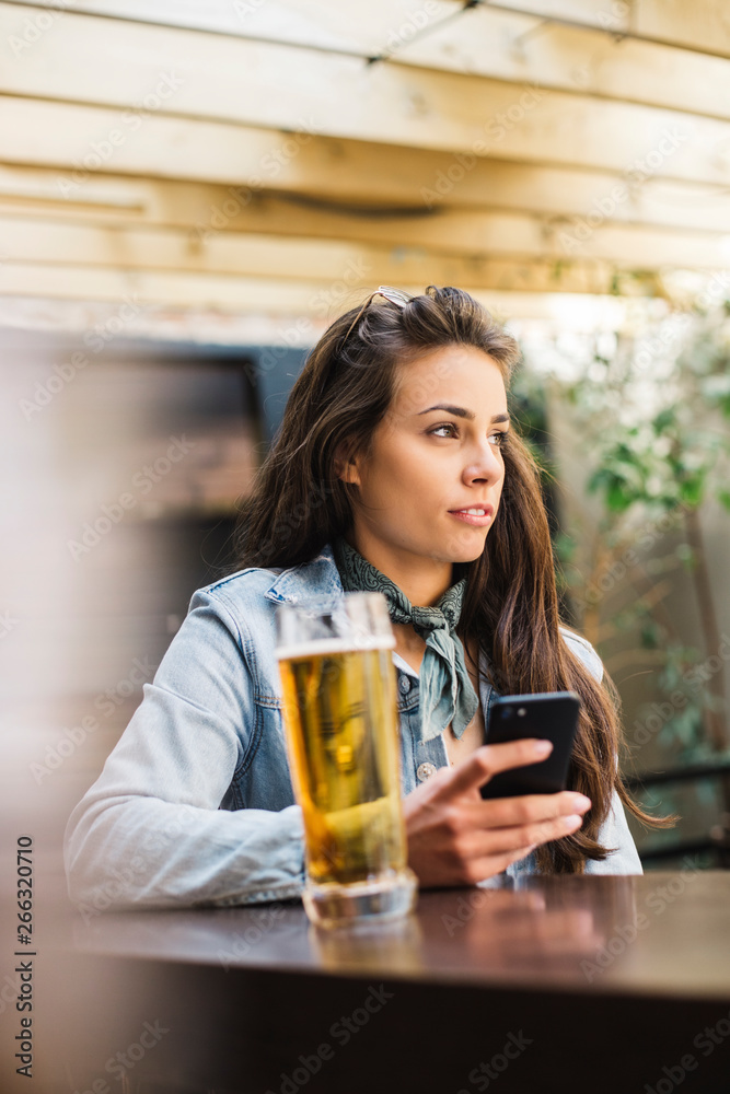 Beautiful woman having beer at the bar.