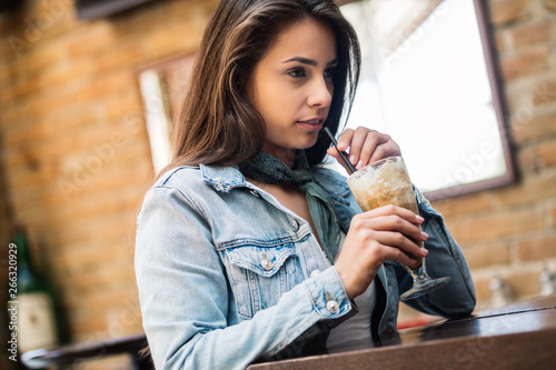 Portrait of smiling beautiful woman drinking cold coffee. Beautiful woman at the coffee shop.