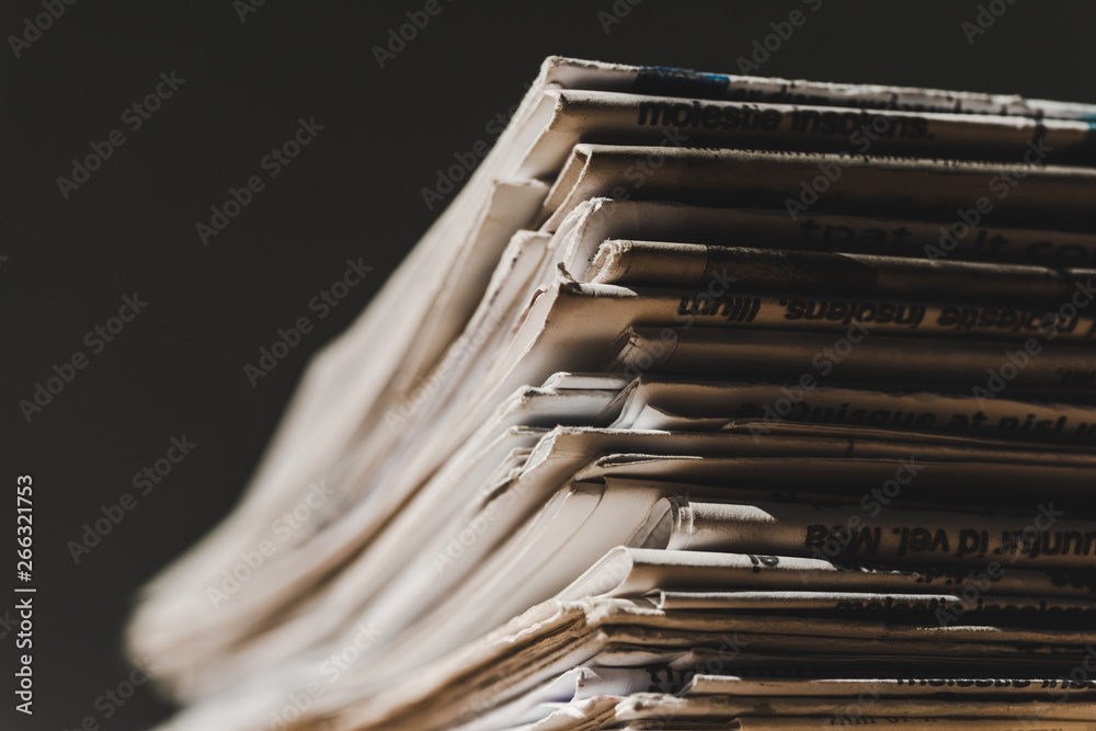 different print newspapers in pile isolated on black different print newspapers in pile isolated on black
