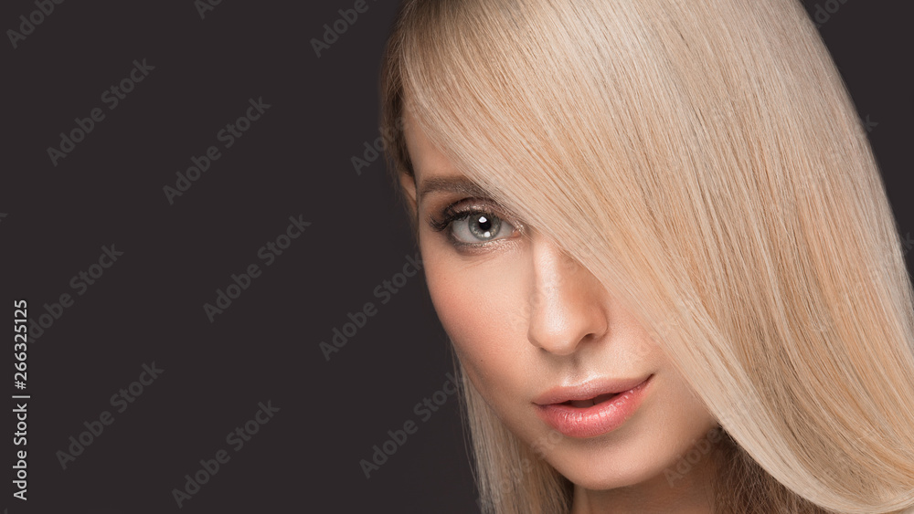 Naklejka premium Beautiful blond girl with a perfectly smooth hair, and classic make-up. Beauty face.