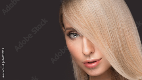 Beautiful blond girl with a perfectly smooth hair, and classic make-up. Beauty face.