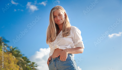 young happy blonde beautiful girl on tropical sea background, smiling happy girl outdoor portrait