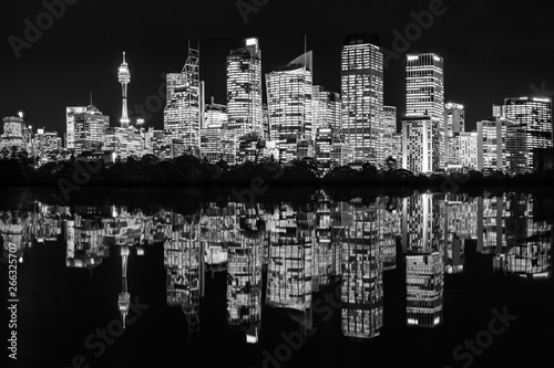 Beautiful Sydney Waterfront Skyline at Night in black and white with reflections in the bay in New South Wales, Australia.