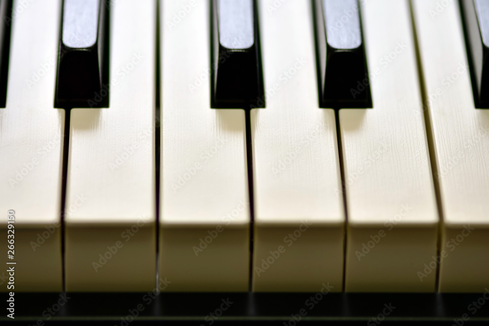 Naklejka premium Keys of a digital piano, soft focusing, creative mood of a person improvisation and creativity. Midi piano keyboard for playing digital music and making remixes.