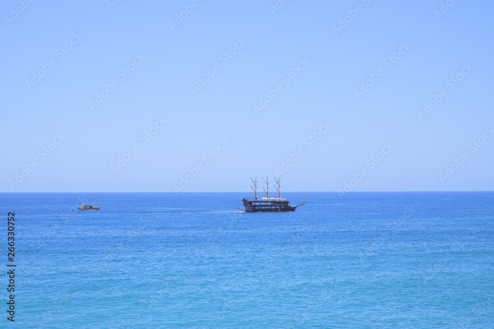 wooden stylized retro sailing ship floats on blue Mediterranean