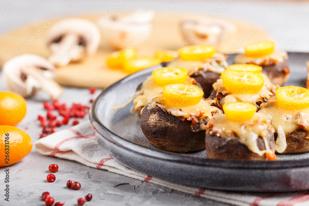 stuffed fried champignons with cheese, kumquats and green peas on a gray concrete background. side view, close up, macro. stuffed fried champignons with cheese, kumquats and green peas on a gray concrete background. side view, close up, macro.