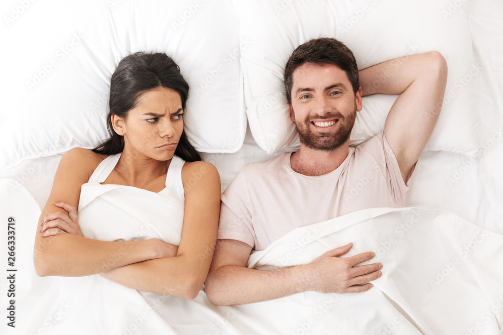 Displeased quarrel young loving couple lies in bed under blanket. Displeased quarrel young loving couple lies in bed under blanket.